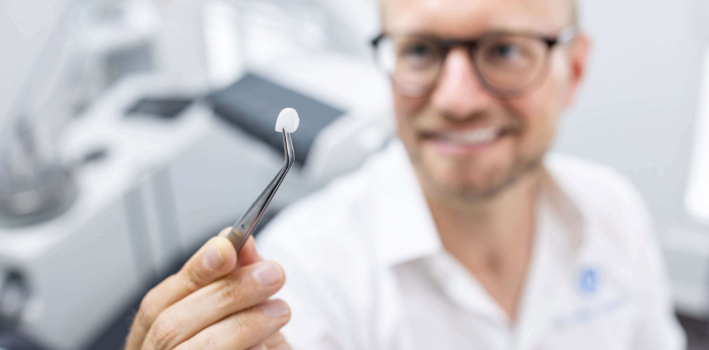 Zahnarzt Dr. Stefan Schultheis und Spezialist für Zahnkosmetik präsentiert Veneers in der Q-Zahnärzte Praxis in Freiburg
